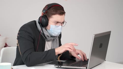 Man Wearing Mask Working At Laptop