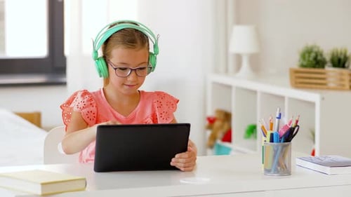 Girl Uses Tablet with Headphones Indoors