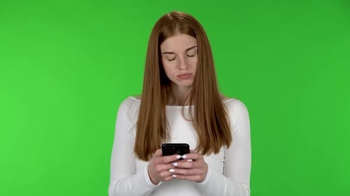 Young Woman Using Cellphone on Green Screen