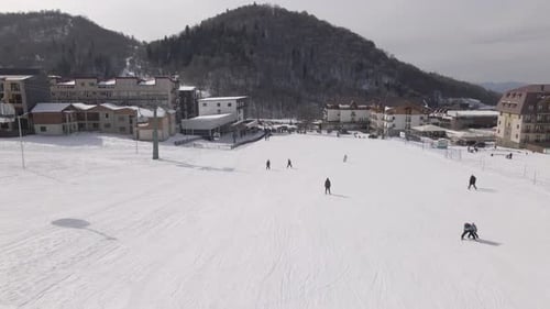Luftaufnahme des Skigebiets mit verschneiten Berghängen und Winterbäumen.