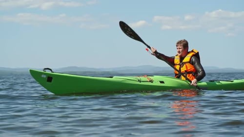 Man Paddling Kayak on a Sunny Lake