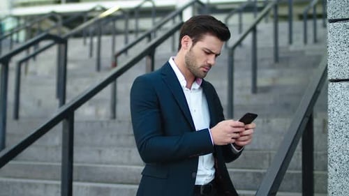 Focused Man Using Phone on Urban Steps