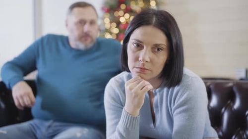 Portrait of Frustrated Caucasian Brunette Woman Sitting on Couch on Christmas Eve and Thinking As