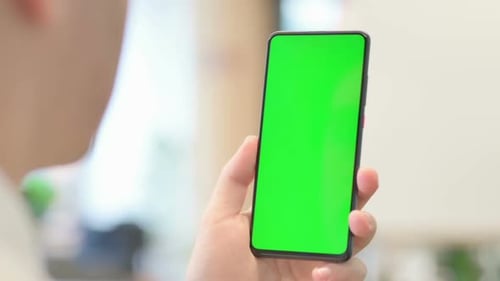 Young Man Using Smartphone with Green Chroma Screen