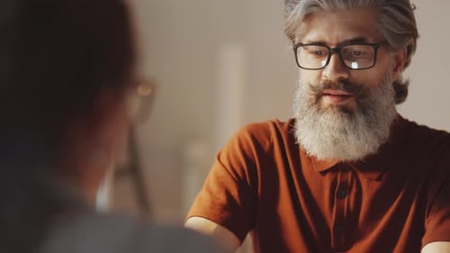 Bearded Businessman Talking with Female Colleague in Office