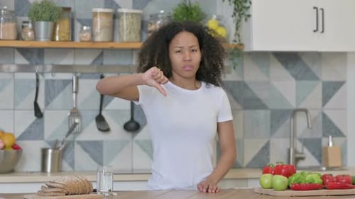 Woman Gives Thumbs Down in Bright Kitchen