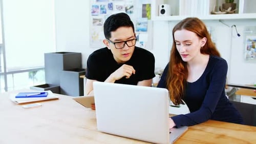 Two Colleagues Collaborating on a Project in Office