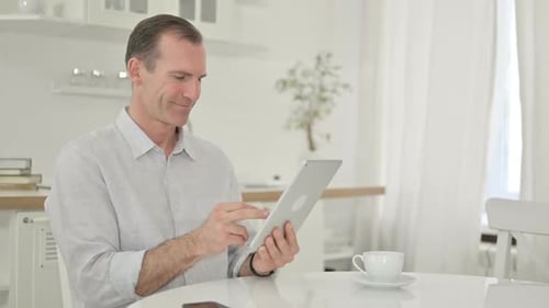Man Using Tablet at Table Inside Home