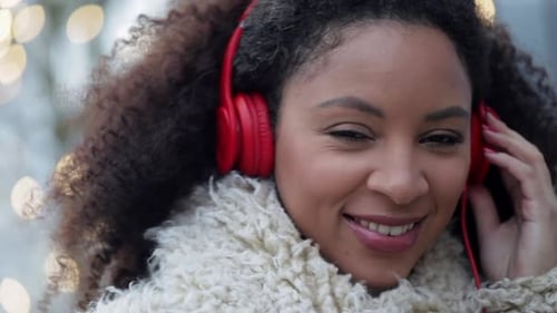 Smiling Woman with Headphones in Urban Setting