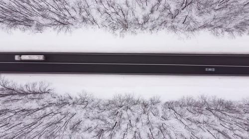 Vue aérienne de la route d'hiver et de la forêt avec des arbres enneigés
