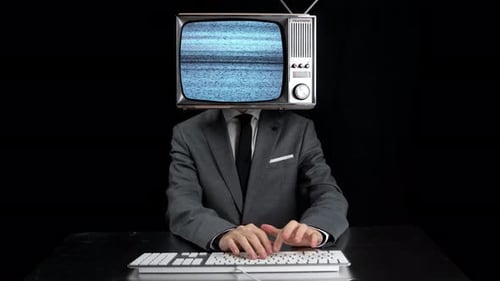 Man with Television Head Typing at Desk
