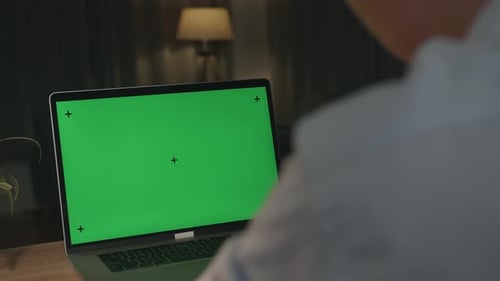 Close Up Asia Male Works On A Laptop Computer With Mock-Up Green Screen At Night