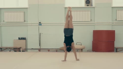Athletisches Mädchen im Fitnessstudio erhebt sich in ihren Armen, geht auf die Kamera zu, während sie sich um ihre Achse dreht