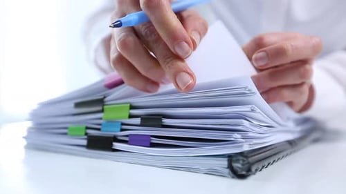 Woman Works Through Documents in Office