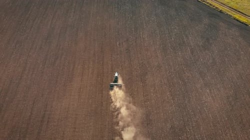 Aerial View Modern Tractor on the Agricultural Field on Sunset Time. Tractor Plowing Land