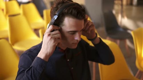 Young Adult with Laptop and Headphones in Auditorium