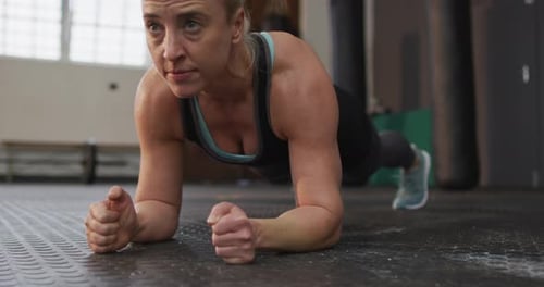 Close up of fit caucasian woman performing plank exercise at the gym