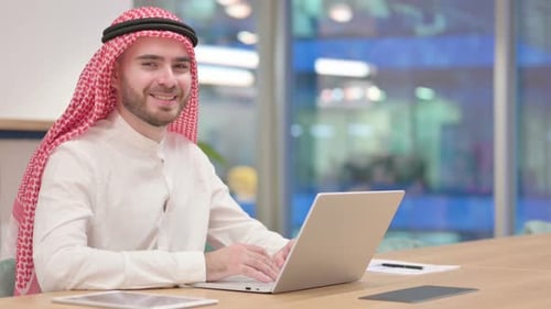 Young Adult Man Typing on Laptop in Office