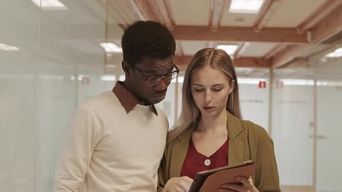 Colleagues Collaborating on a Tablet in Bright Office