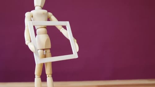 Wooden Mannequin Holding a Picture Frame