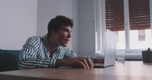 Jovem europeu chamada vídeo chat no laptop sentado em uma mesa