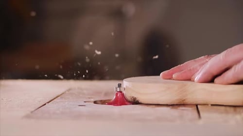 Craftsman Routing Wood with Hand in Workshop