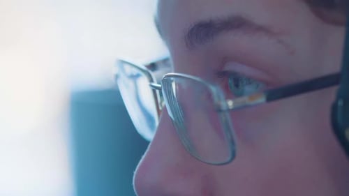 Closeup of Eyes of a Teenager in Eyeglasses His Eyes Run Around the Computer Monitor