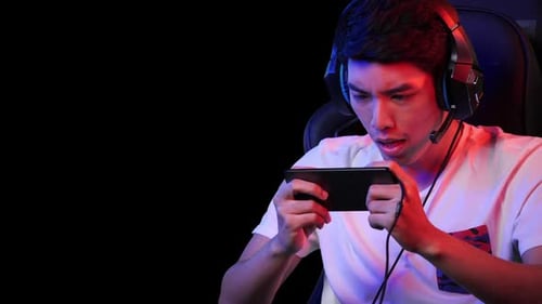 Young Adult Playing Game on Smartphone with Headset