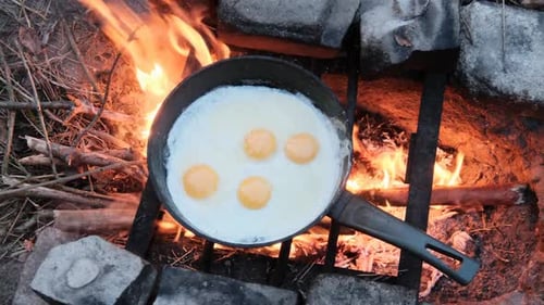 Eggs Cooking over Bright Campfire