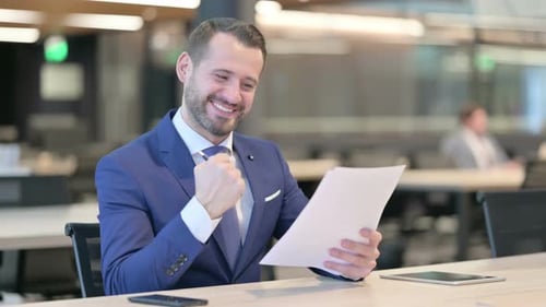 Cheerful Adult Reviews Documents at a Desk