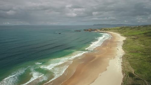 Aerial View Sandy Beach Ocean Foamy Waves Drops to Coastline in White Beach Antrim County