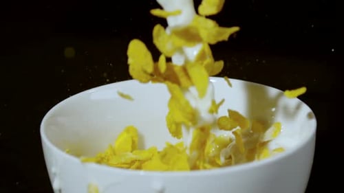 Cornflakes and Milk Pouring into a Bowl