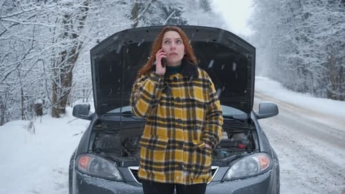 Woman on Phone With Car Trouble in Winter