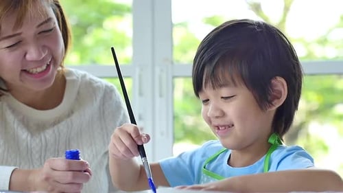Woman and Child Painting With Blue Paint Indoors