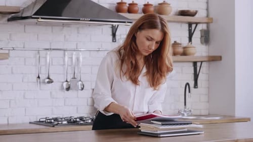 Woman Working At Kitchen Counter With Laptop