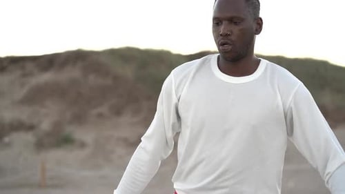 Man Practices Martial Arts on Sandy Beach