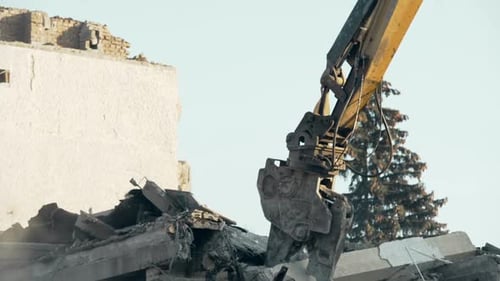 Procédure de démolition de bâtiments, excavatrice à grande portée éliminant l'ancienne construction