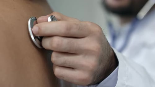 Doctor Listening to Patient's Back With Stethoscope