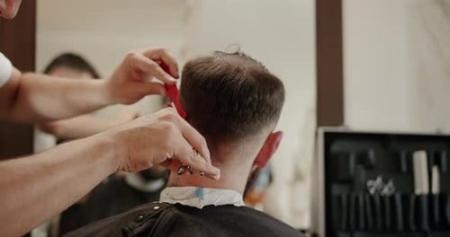 Barber Cutting Hair with Scissors in Barbershop