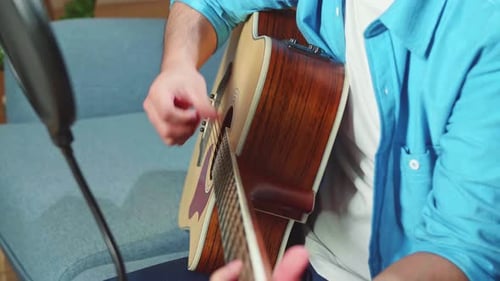 Man Playing Guitar And Sing A Song. The Male Is Streaming For His Social Media Channel