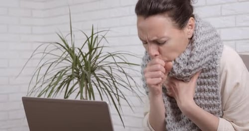Woman Coughing with a Gray Scarf Indoors