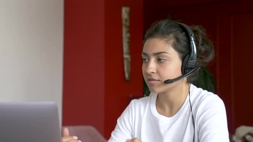 Woman Using Laptop With Headset for Video Conference