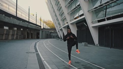 Sporty African American Athlete Training Alone Outdoors Warming Up His Legs Before Run Workout at