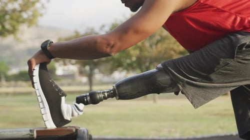 Side view man with prosthetic leg stretching