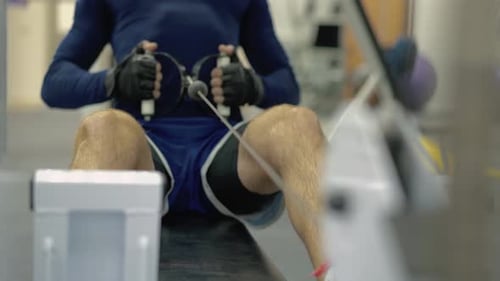 Person Using Rowing Machine at Gym