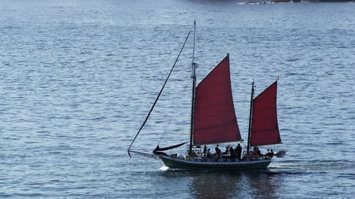 Slow motion of boat full of people sailing through the ocean