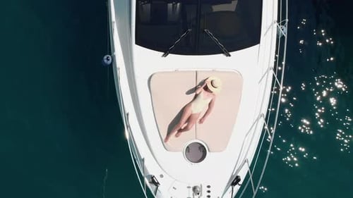 Luftaufnahme einer jungen Frau, die sich auf einer Yacht entspannt und sonnt