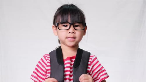 Smiling Child With Backpack and Glasses