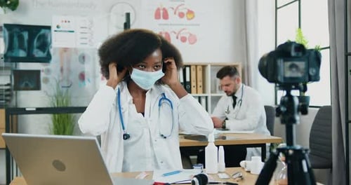 Mujer-doctora muestra cómo usar una máscara protectora ante la cámara
