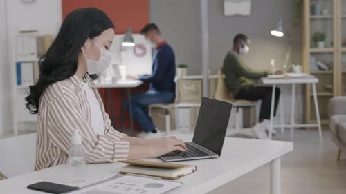Woman Typing On Laptop in Modern Office